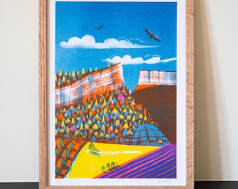 May include: A framed art print featuring a colorful landscape scene. The artwork depicts a canyon with a blue sky, white clouds, and two birds. The foreground shows a yellow field and purple rows, with a forest of trees in the middle.