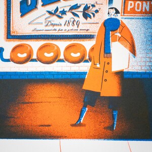 May include: A woman in a blue scarf and orange coat walks past a sign that reads "Suze" with the text "Depuis 1889" and "Liqueur inimitable faite de gentianes sauvages". Three orange circles are visible on the wall behind the sign.