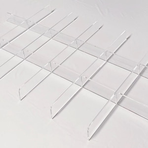 Peut inclure: Séparateurs d'étagères en acrylique transparent, disposés en grille. Les séparateurs transparents créent une série de compartiments rectangulaires. Design simple et moderne, pour organiser les étagères.