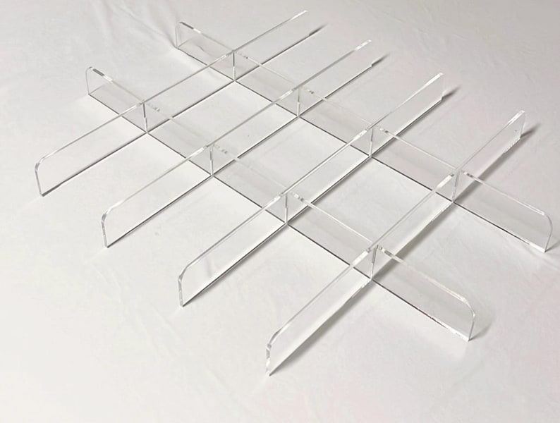 Puede incluir: Un juego de divisores de acr&iacute;lico transparente para organizar estantes. Los divisores tienen forma de 'L' y se pueden usar para crear m&uacute;ltiples compartimentos en un estante.