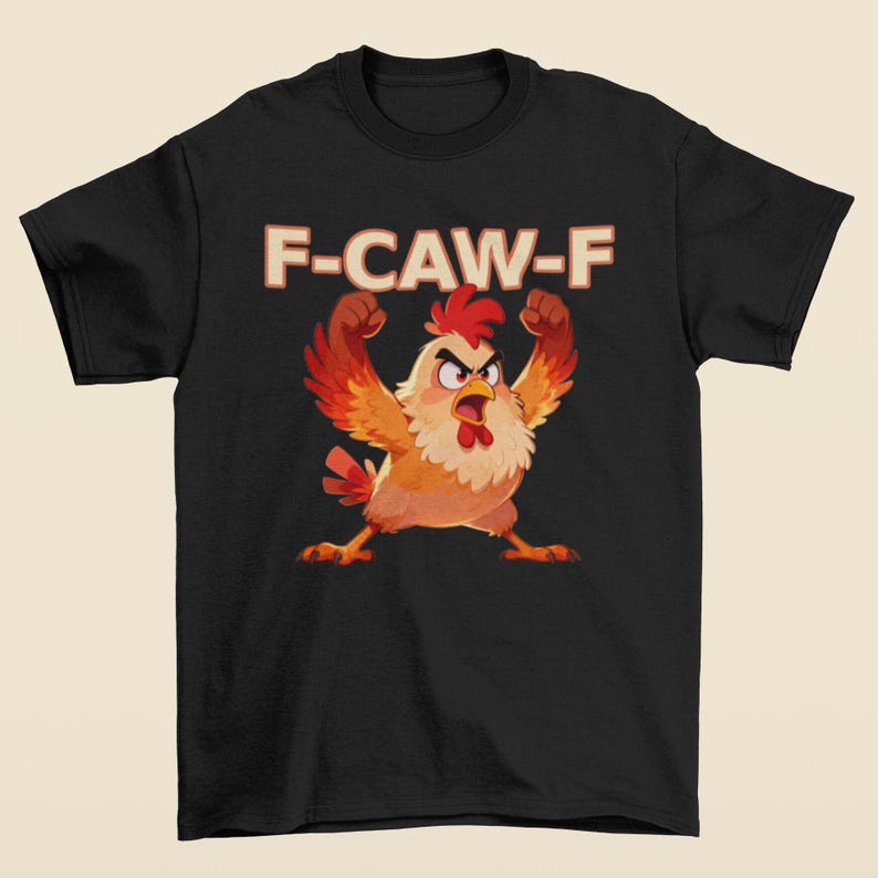 May include: Black t-shirt featuring a cartoon chicken with raised fists and an angry expression. The text "F-CAW-F" is printed above the chicken in a bold, retro font. The chicken is primarily orange, red, and yellow.