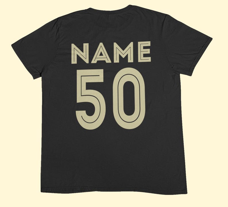 May include: A black short-sleeved t-shirt featuring the word NAME printed in large beige capital letters above the number 50 in a matching beige font. The design is centered on the back of the garment, utilizing a clean, bold, sans-serif typeface.