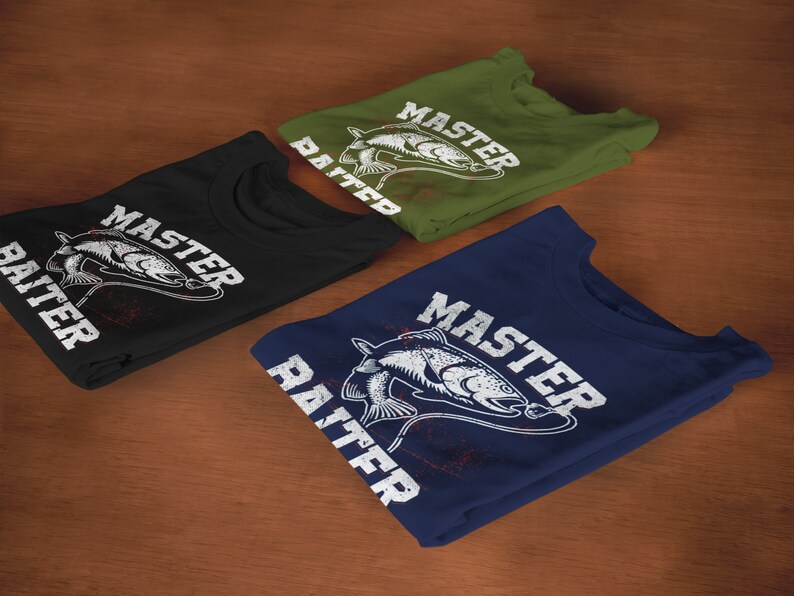 May include: Three folded crew neck t-shirts in black, olive green, and navy blue. Each shirt features a white graphic print of a fish on a fishing line with the text "MASTER BAITER" in a distressed, bold, capitalized font across the chest.