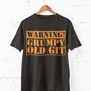 Könnte beinhalten: Schwarzes T-Shirt mit einer orangefarbenen Grafik, auf der "WARNING! GRUMPY OLD GIT" steht.