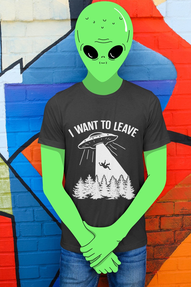 May include: A green alien wearing a black t-shirt with a white graphic of a UFO and the text "I WANT TO LEAVE".