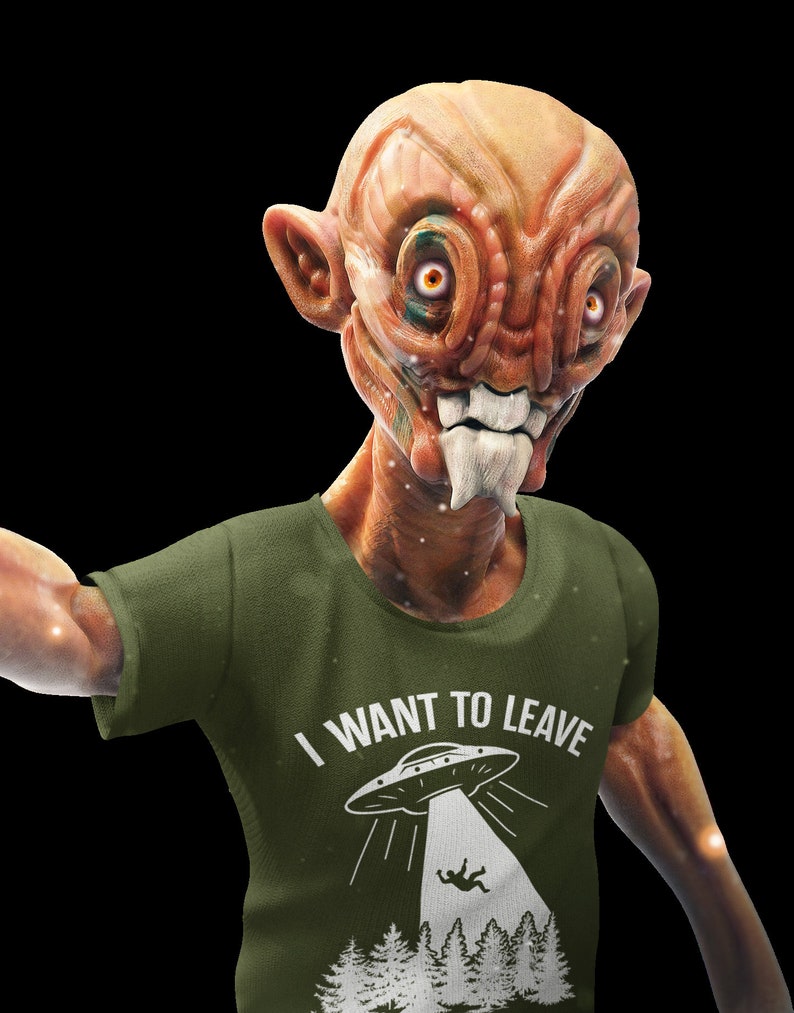 May include: A green t-shirt with a white graphic of a UFO and the text "I WANT TO LEAVE". The graphic shows a person falling from the UFO into a forest.