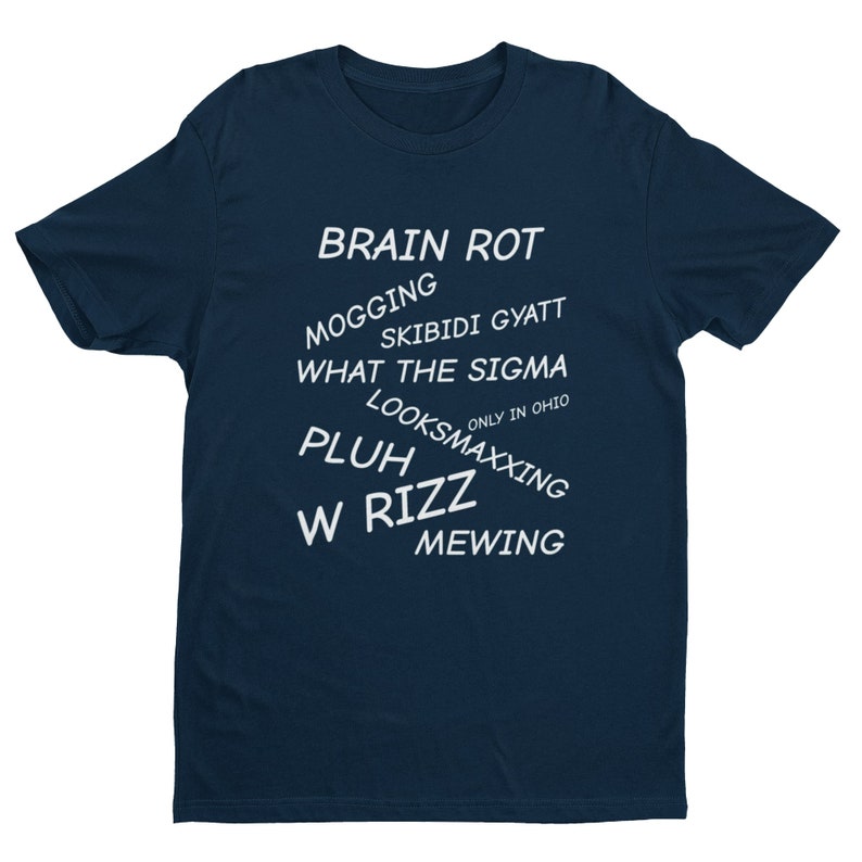 May include: A navy blue t-shirt with white text that reads "BRAIN ROT", "MOGGING", "SKIBIDI GYATT", "WHAT THE SIGMA", "ONLY IN OHIO", "LOOKSMAXXING", "PLUH", "W RIZZ", and "MEWING".