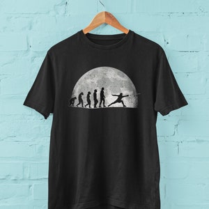 Evolution Of The Sword Fencer T Shirt from ape through prehistoric man to fencer fencing in the moonlight