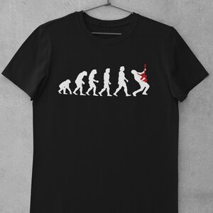 May include: Black t-shirt featuring a white graphic of the evolution of man, culminating in a person playing an electric guitar.