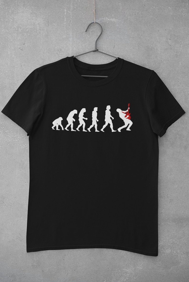 May include: Black t-shirt featuring a white graphic of the evolution of man, culminating in a person playing an electric guitar.