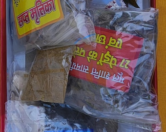 May include: A red box filled with various small packages containing herbs and spices. The packages are labeled in Hindi with the text "Mul Shanti Saamgri" and "27 Gaon Ke 27 Pedon Ke Patte Evam Chhaal". There are also two small bottles labeled "Jamun" and "Sepen".