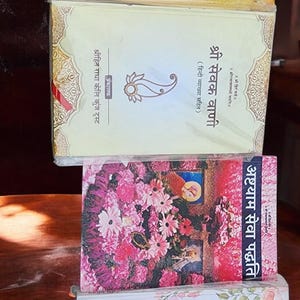 Puede incluir: Una pila de libros con cubiertas coloridas. Los libros presentan texto en idioma extranjero, con diseños florales y de cachemira. Los títulos incluyen "Shri Radha Sudhanidhi Stotram" y "Ashtayam Seva Paddhati".