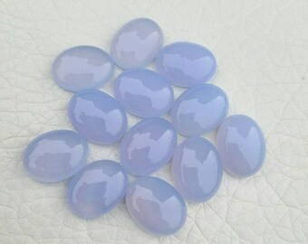 Naturalny owalny kaboszon z chalcedonu o wymiarach 14×10 mm. Kalibrowany kamień szlachetny z niebieskiego chalcedonu.