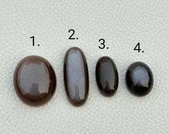 May include: Four oval-shaped black stones with a slight sheen. The stones are numbered 1 through 4.