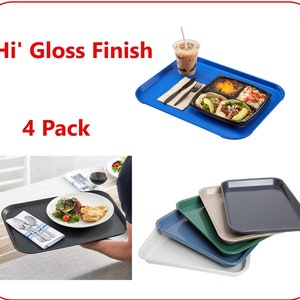 May include: Four pack of black plastic serving trays with a high gloss finish. The trays are shown stacked and being held by a person. The text "Hi' Gloss Finish" and "4 Pack" is visible in the image.