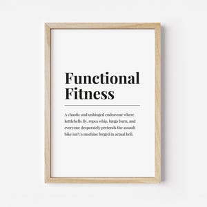 May include: A framed print with the words "Functional Fitness" in bold black font. Below, a humorous description of functional fitness is printed in a smaller font. The frame is a light wood color.