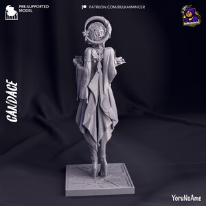May include: A gray 3D-printed figurine of a character named Candace, standing on a square base. The figure is wearing a detailed outfit with flowing robes and a headpiece. The image includes text that says "PRE-SUPPORTED MODEL" and "PATREON.COM/BULKAMANCER".