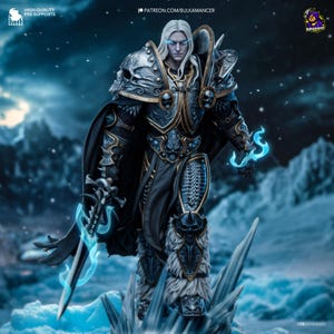 May include: A detailed figurine of a character in ornate armour, featuring a skull motif and glowing blue accents. The figure has long white hair and is holding a sword with a blue energy effect. The background is a snowy landscape.