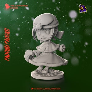 May include: A 3D-printed figurine of a character in a winter outfit, with a hat and cape. The figurine is on a round base. The text "PADORU PADORU" is on the left side, and "PRE-SUPPORTED MODEL" is at the top. The background is green with white snowflakes.