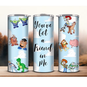 May include: Three stainless steel tumblers with a blue background and white clouds. The tumblers feature characters from the Toy Story movie franchise, including Woody, Buzz Lightyear, Rex, Slinky Dog, and Mr. and Mrs. Potato Head. The middle tumbler has the text "You've got a friend in me".