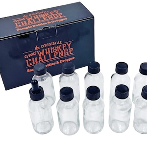 Puede incluir: Un juego de diez botellas de vidrio transparente con tapas negras y una botella gotero. Las botellas están etiquetadas con "The Original Great Whiskey Challenge Sample Bottles & Dropper".