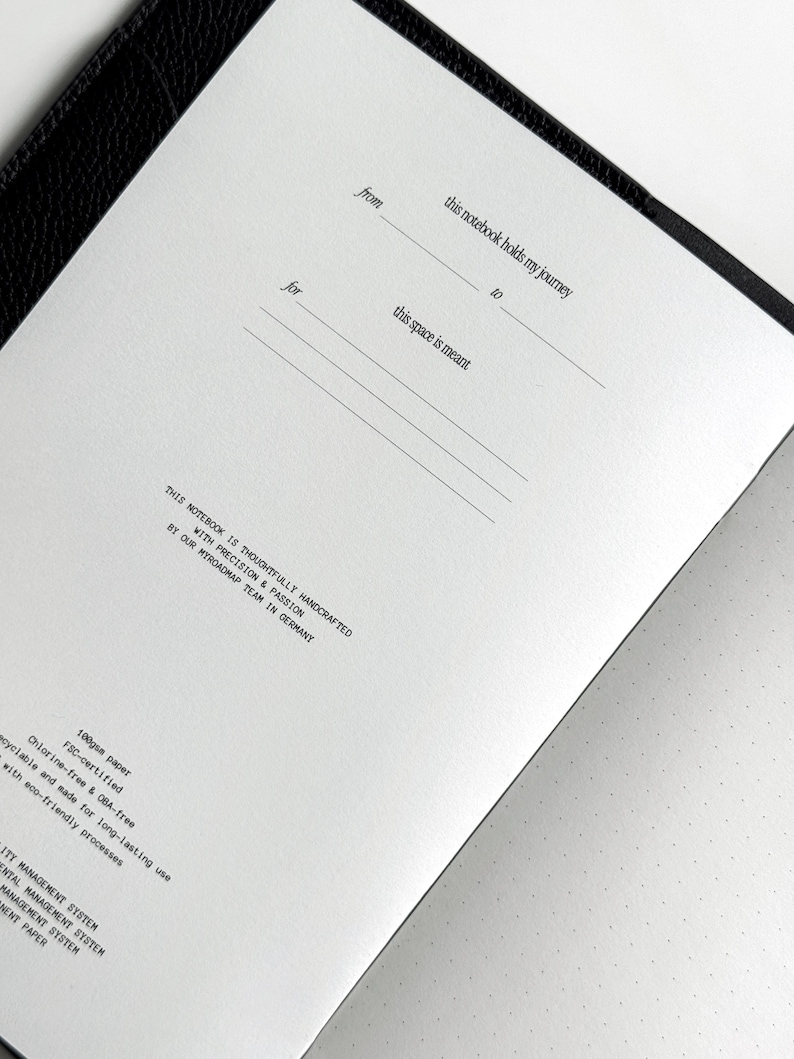 K&ouml;nnte beinhalten: Offenes Notizbuch mit linierten Seiten und Punktrasterseiten. Das Notizbuch tr&auml;gt die Aufschrift "from", "for", "this notebook holds my journey" und "this space is meant". Es wurde mit Pr&auml;zision und Leidenschaft vom MyRoadmap-Team in Deutschland gefertigt.