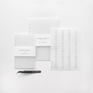 Può includere: Due divisori per planner A5 bianchi con il testo "PERSONAL DIVIDERS transparent MY-ROADMAP" e "PLANNER DIVIDERS A5 transparent MY-ROADMAP" stampato su di essi. È anche mostrato un foglio di divisori per planner trasparenti con etichette mensili e annuali. Le etichette includono i mesi dell'anno, come gennaio, febbraio, marzo e aprile, nonché categorie come "Progetti", "Finanze", "Lavoro", "Da fare", "Faccende", "Ordini", "Appuntamenti", "Budget", "Obiettivi", "Contatti", "Redditi", "Spese", "Piano aziendale", "Benessere" e "Social media".