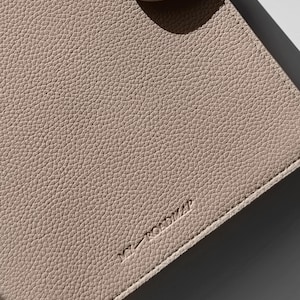 May include: A light beige leather notebook with the word "remarkable" embossed on the cover.