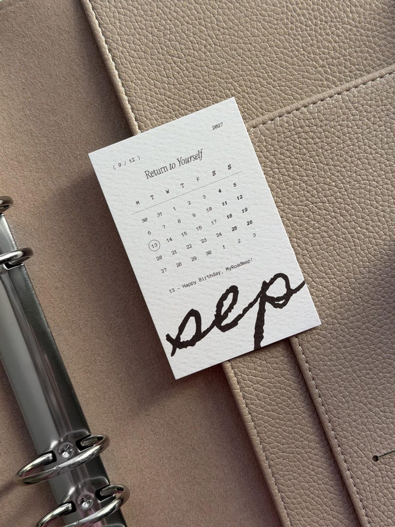 May include: A white rectangular calendar card for September 2027 with the text Return to Yourself and sep written in large black script. The calendar displays days of the week and dates, with the number 13 circled and the text Happy Birthday, MyRoadmap!