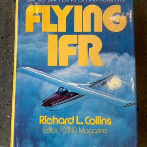 May include: A book titled "Flying IFR: A Practical Guide to Day-to-Day Flying on Instruments" by Richard L. Collins, Editor of FLYING Magazine. The cover features a yellow and blue color scheme with a small airplane flying through the clouds.