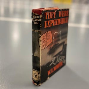 Puede incluir: Un libro de bolsillo vintage titulado "They Were Expendable" de W.L. White. La portada presenta un diseño rojo y negro con una escena de un barco en el mar. El libro es un libro de guerra imperativo.