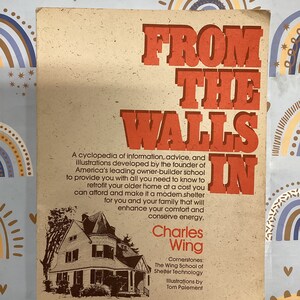 May include: A book titled "From the Walls In" by Charles Wing. The book cover features a brown house with white trim and a white door. The book is about home renovation and energy conservation. The text on the cover reads "Cornerstones: The Wing School of Shelter Technology. Illustrations by Tom Paiement."