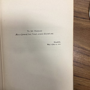 以下が含まれることがあります： 「To My Husband」と書かれた本のページ。手書きのメッセージが続き、「Also a General, but, I trust, a more discreet one.」と書かれています。テキストは「Menabilly, May 5-July 19, 1945.」と署名されています。