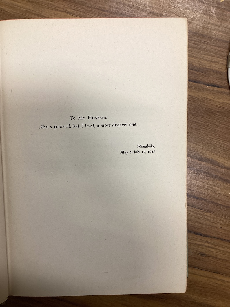 以下が含まれることがあります： 「To My Husband」と書かれた本のページ。手書きのメッセージが続き、「Also a General, but, I trust, a more discreet one.」と書かれています。テキストは「Menabilly, May 5-July 19, 1945.」と署名されています。