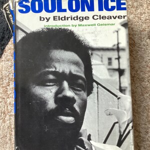May include: A vintage paperback book titled "SOUL ON ICE" by Eldridge Cleaver. The cover features a black and white portrait of a man with a beard. The title is in large blue letters.