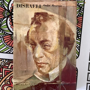 Può includere: Una copertina di libro vintage con un ritratto di un uomo. Il titolo del libro è "DISRAELI" di Andre Maurois.