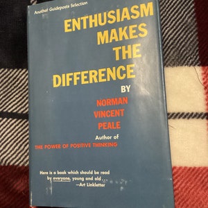 Może przedstawiać: Niebieska okładka książki z tytułem "Entuzjazm czyni różnicę" autorstwa Normana Vincenta Peale, autora "Siły pozytywnego myślenia". Cytat "Oto książka, którą powinien przeczytać każdy, młody i stary... -Art Linkletter" jest wydrukowany na dole okładki.