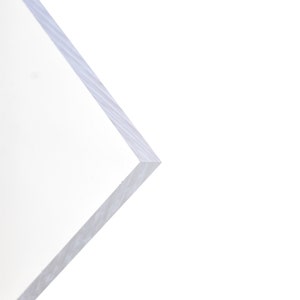 May include: Close-up of the edge of a clear, white acrylic sheet.