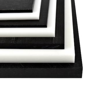 May include: Stack of black and white plastic sheets. The sheets are layered on top of each other, with the black sheets on the bottom and the white sheets on top.
