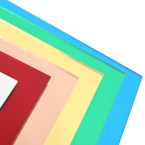 May include: Stack of colorful acrylic sheets in shades of blue, green, yellow, peach, and red.