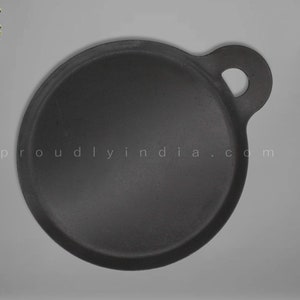 K&ouml;nnte beinhalten: Eine schwarze Gusseisen-Dosa-Pfanne mit einem einzigen Griff. Die Pfanne ist rund und hat einen leicht erh&ouml;hten Rand. Der Griff ist an der Seite der Pfanne befestigt und hat ein kleines Loch.