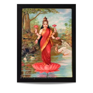 May include: A framed painting of a Hindu goddess standing on a pink lotus flower. She is wearing a red sari and has four arms. She is surrounded by a green and blue landscape with a white elephant in the background. The painting is titled "Proudlyindia.com".