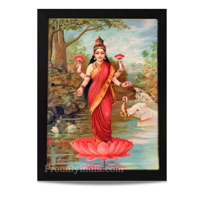 May include: A framed painting of a Hindu goddess standing on a pink lotus flower. She is wearing a red sari and has four arms. She is surrounded by a green and blue landscape with a white elephant in the background. The painting is titled "Proudlyindia.com".