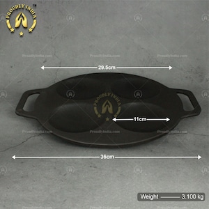 Puede incluir: Sart&eacute;n de hierro fundido negro con tres depresiones redondas, que mide 11 cm de di&aacute;metro y 36 cm de largo. La sart&eacute;n tiene dos asas y pesa 3,100 kg.