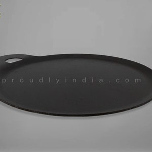 K&ouml;nnte beinhalten: Eine schwarze Gusseisen-Dosa-Pfanne mit einem Griff. Die Pfanne ist rund und hat einen leicht erh&ouml;hten Rand. Der Text "proudlyindia.com" ist auf die Pfanne gedruckt.