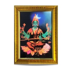 May include: A framed picture of a Hindu goddess with four arms playing a stringed instrument. She is sitting on a lotus flower and has a crescent moon above her head. The frame is gold and has a decorative border.