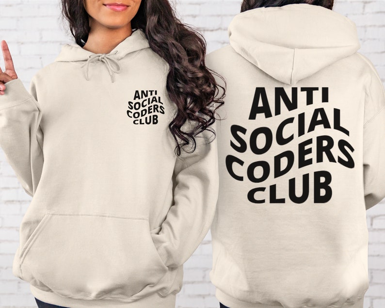 Op de afbeelding: Een cr&egrave;mekleurige hoodie met een zwarte afbeelding waarop "ANTI SOCIAL CODERS CLUB" staat op de achterkant en een kleinere versie van de afbeelding op de voorkant.