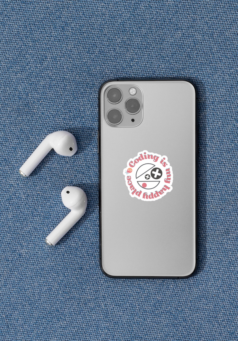 May include: A silver smartphone with a sticker that reads "Coding is my happy place" in pink and white. Two white wireless earbuds are next to the phone on a blue denim surface.