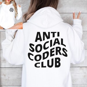 Op de afbeelding: Witte hoodie met een zwarte grafische print die "ANTI SOCIAL CODERS CLUB" zegt in een gestileerd lettertype.