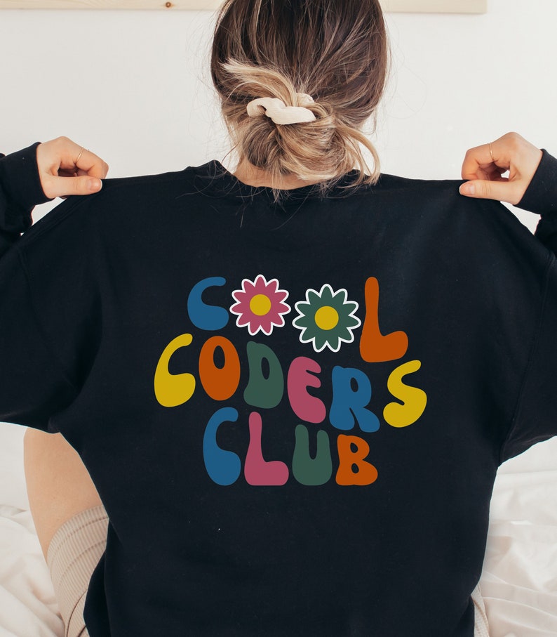 Peut inclure: Sweat-shirt noir avec un graphisme r&eacute;tro color&eacute; qui dit "Cool Coders Club" avec des fleurs.